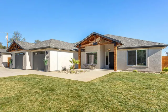 a front view of a house with a garden and yard
