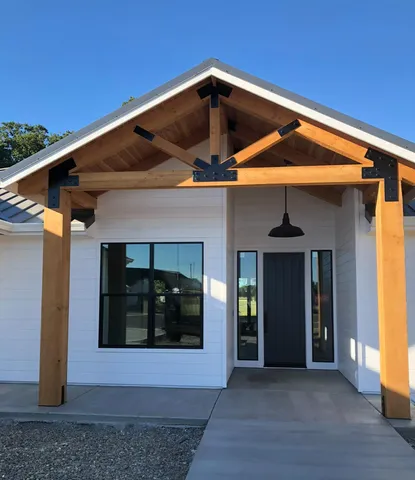 a view of a small house with wooden fence