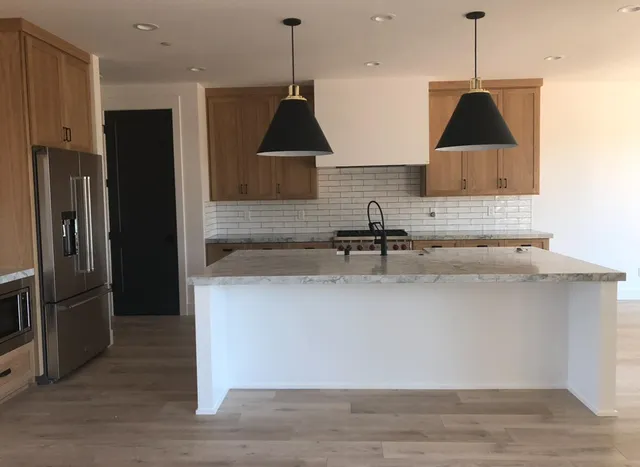 a kitchen with a sink a refrigerator a stove and cabinets