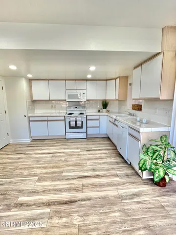 a large kitchen with kitchen island a sink stainless steel appliances and cabinets