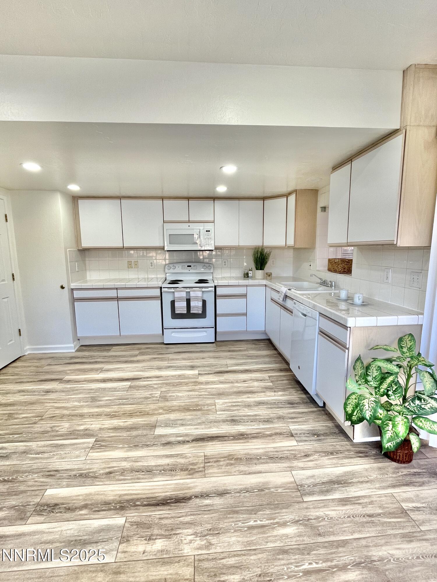 a large kitchen with kitchen island a sink stainless steel appliances and cabinets
