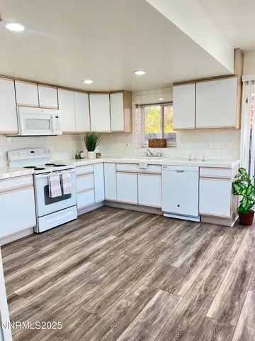 a large kitchen with stainless steel appliances granite countertop a stove a sink and a refrigerator