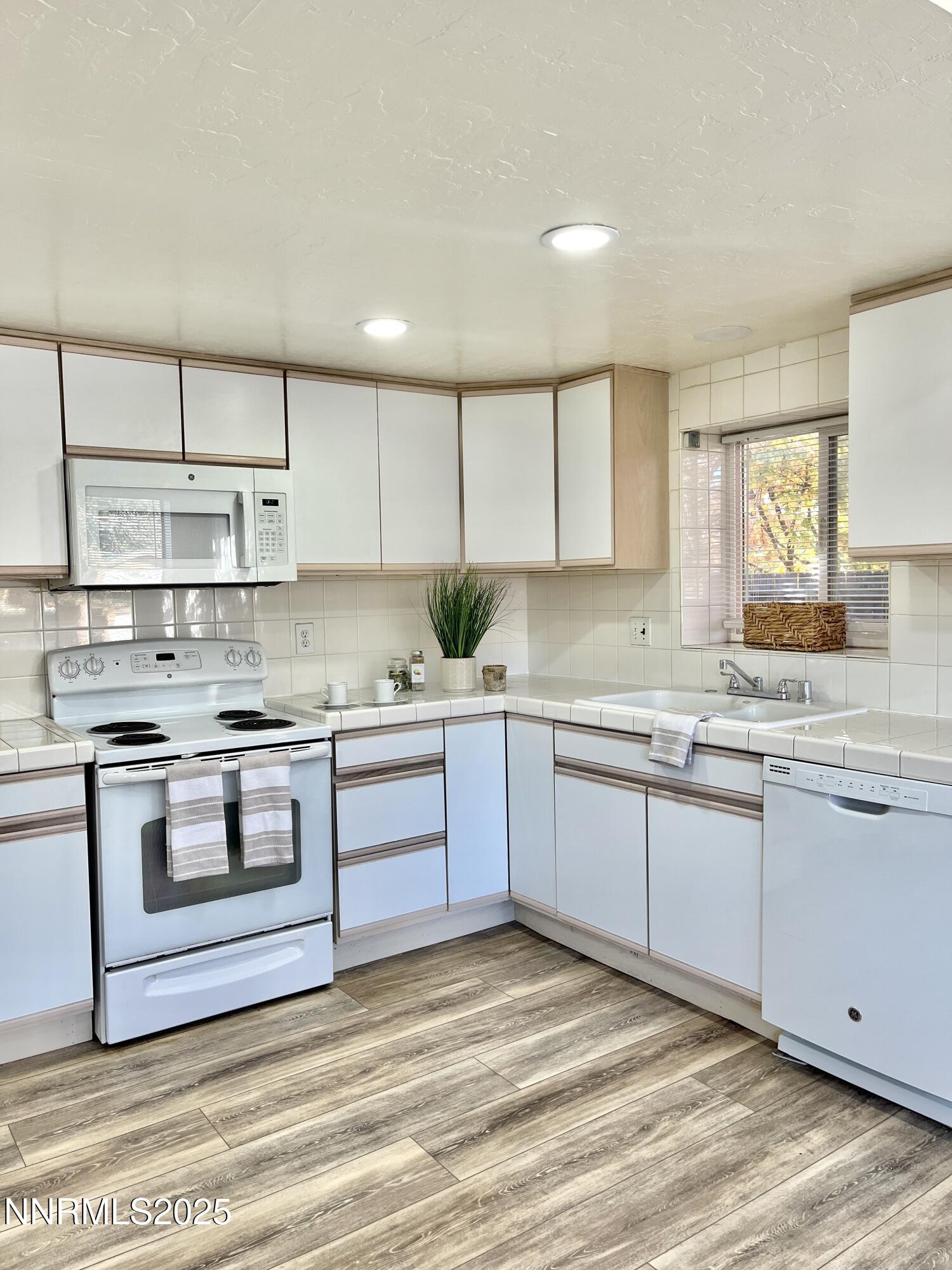 506 East Taylor Street Reno, NV 89502 - Photo 3 of 12 a kitchen with stainless steel appliances granite countertop a stove a sink and white cabinets