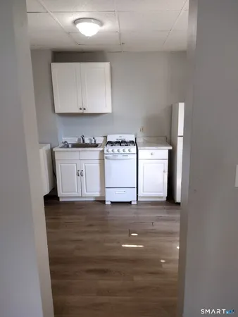 a kitchen with stainless steel appliances granite countertop a stove and a white cabinets