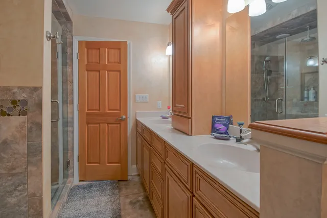 a bathroom with a double vanity sink a mirror and a shower