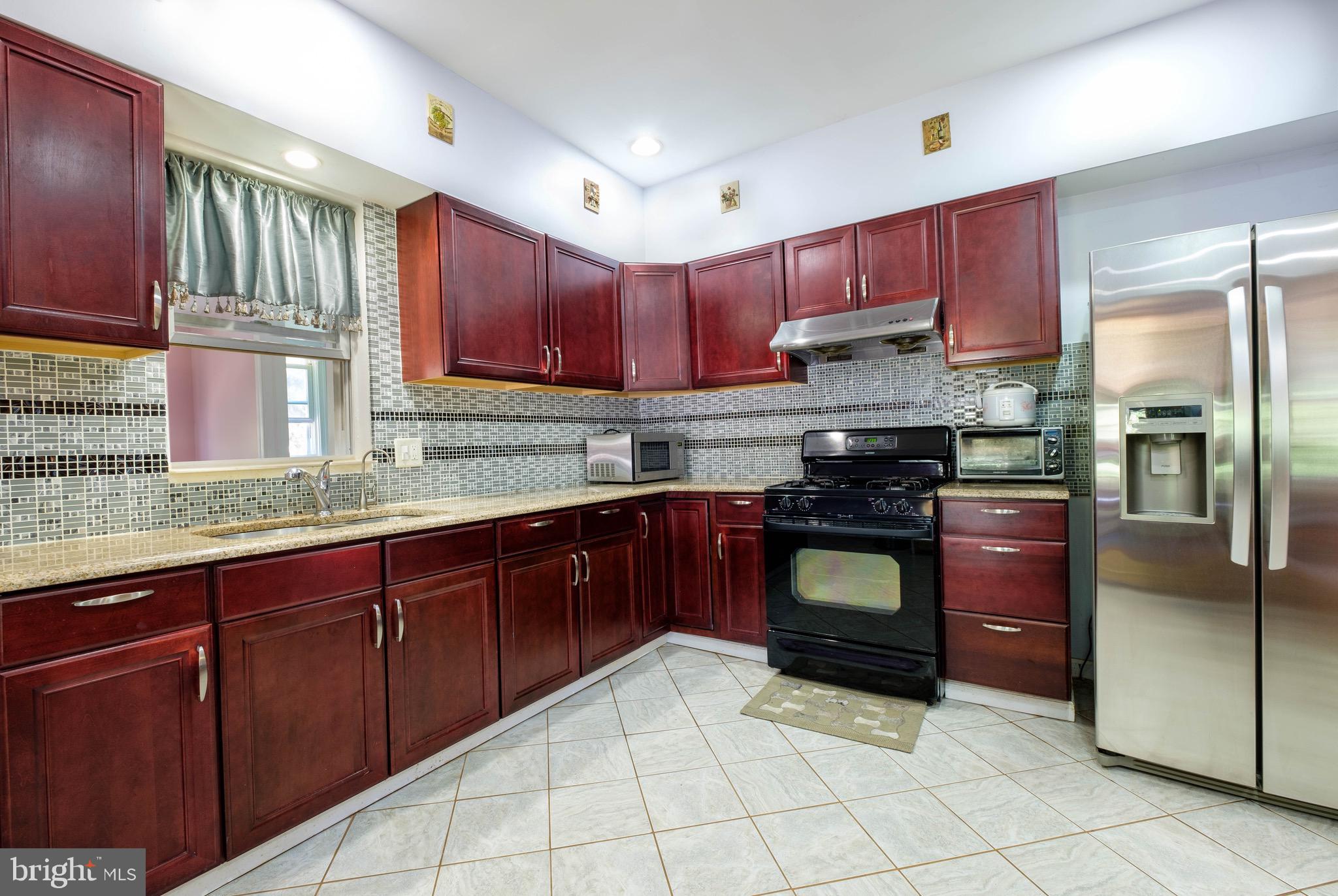 a kitchen with stainless steel appliances granite countertop a refrigerator a stove a sink and dishwasher