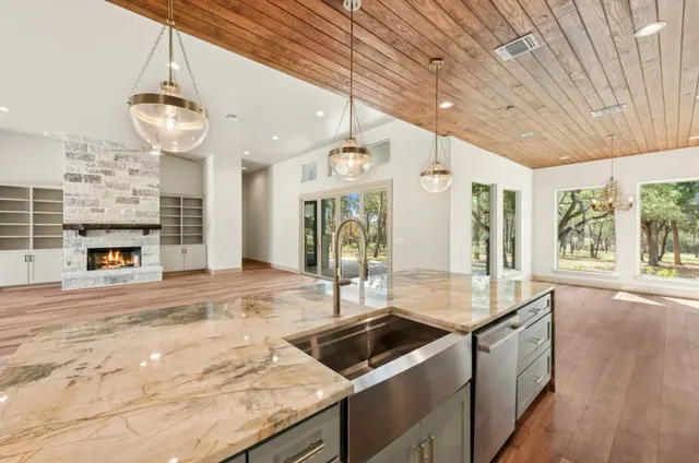a kitchen with kitchen island granite countertop a sink and a stove