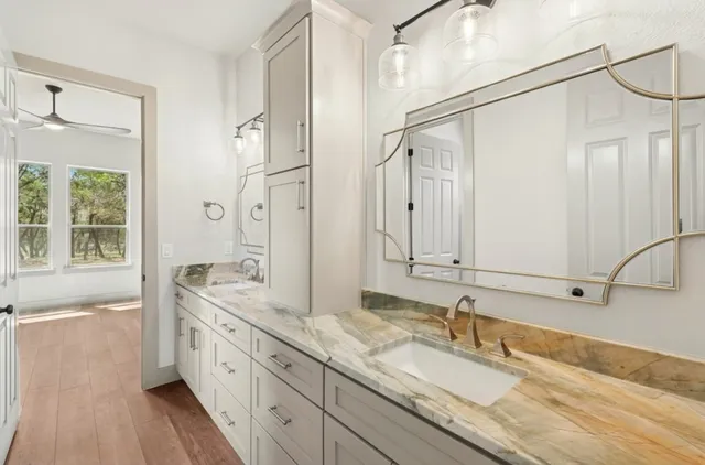 a spacious bathroom with a granite countertop sink mirror and a bath tub