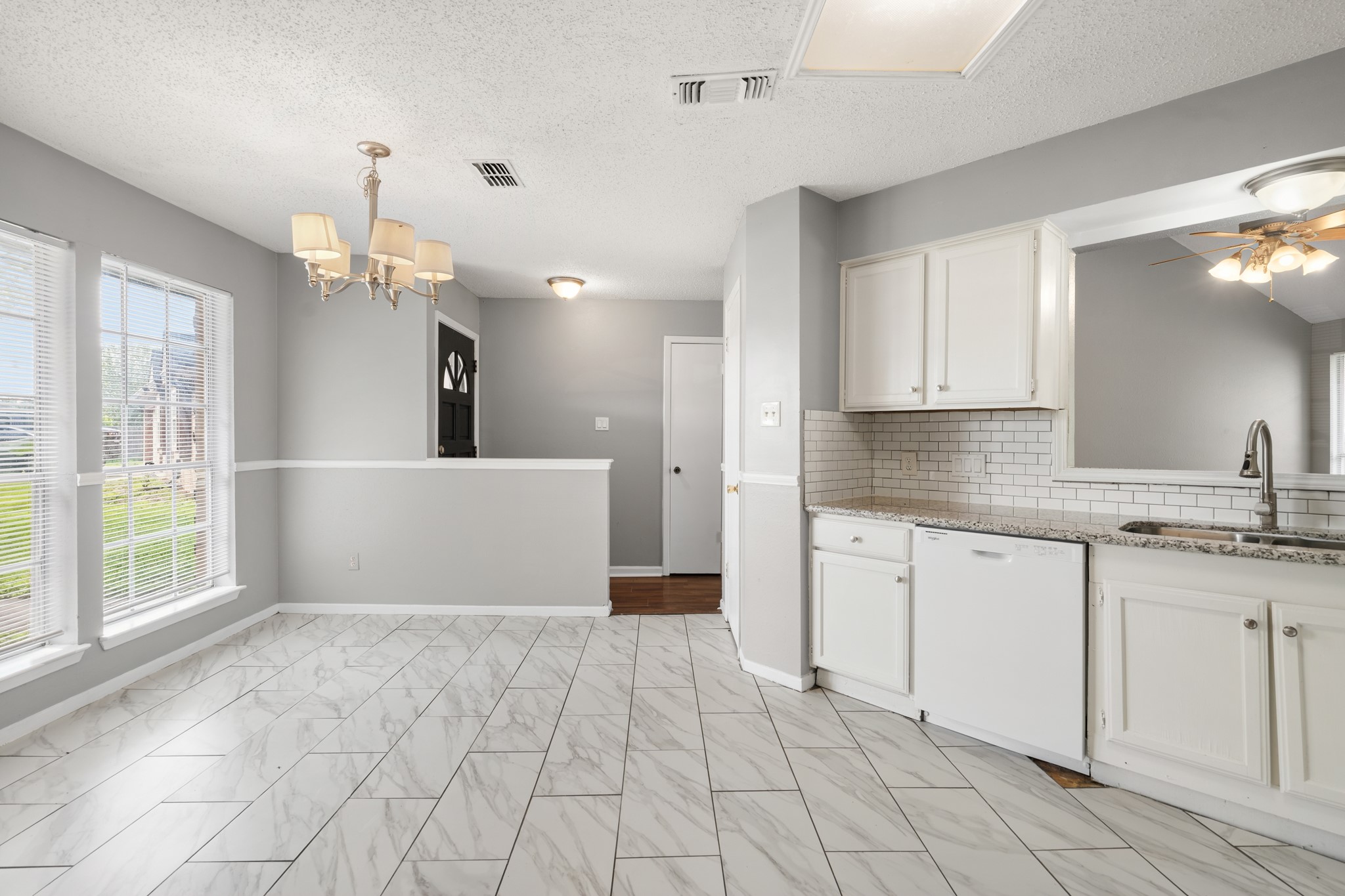 2220 Spruce Drive Rosenberg, TX 77471 - Photo 7 of 18 The kitchen includes a stylish backsplash and opens to a clear view of the living room, creating a connected and open feel.