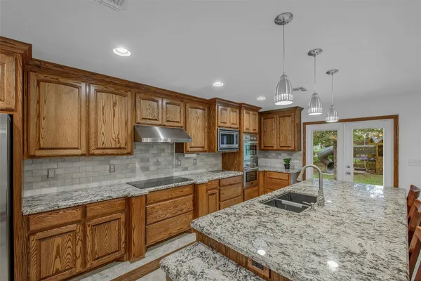 a kitchen with stainless steel appliances granite countertop sink stove and refrigerator