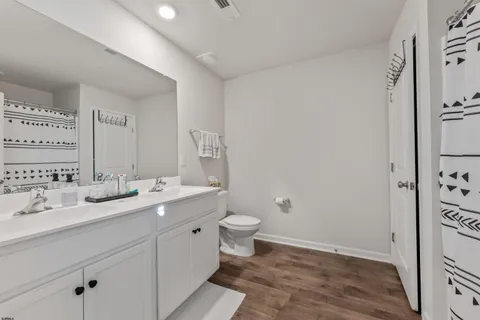 a bathroom with a double vanity sink mirror and toilet