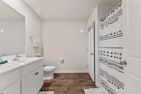 a bathroom with a granite countertop sink a toilet and a mirror