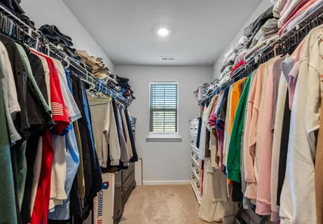 a view of walk in closet with clothes