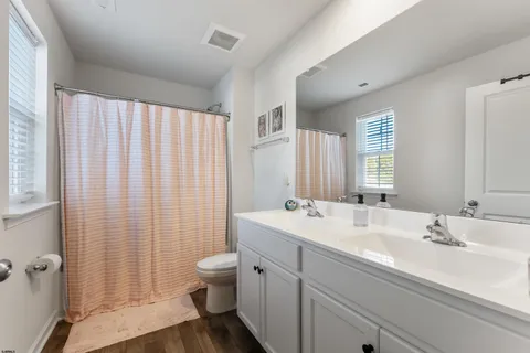 a bathroom with a double vanity sink toilet and shower
