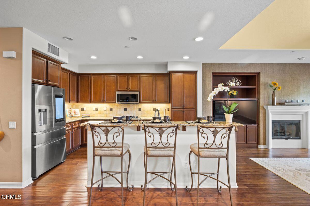 3004 Moonlight Park Avenue Oxnard, CA 93036 - Photo 16 of 28 a kitchen with stainless steel appliances kitchen island granite countertop a refrigerator and a stove top oven