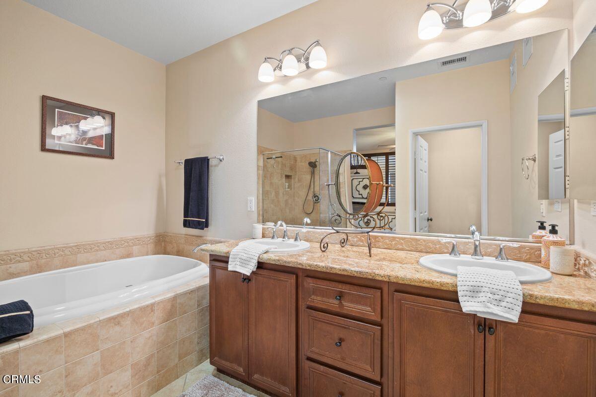 3004 Moonlight Park Avenue Oxnard, CA 93036 - Photo 7 of 28 a bathroom with a bathtub a double vanity sink and a mirror