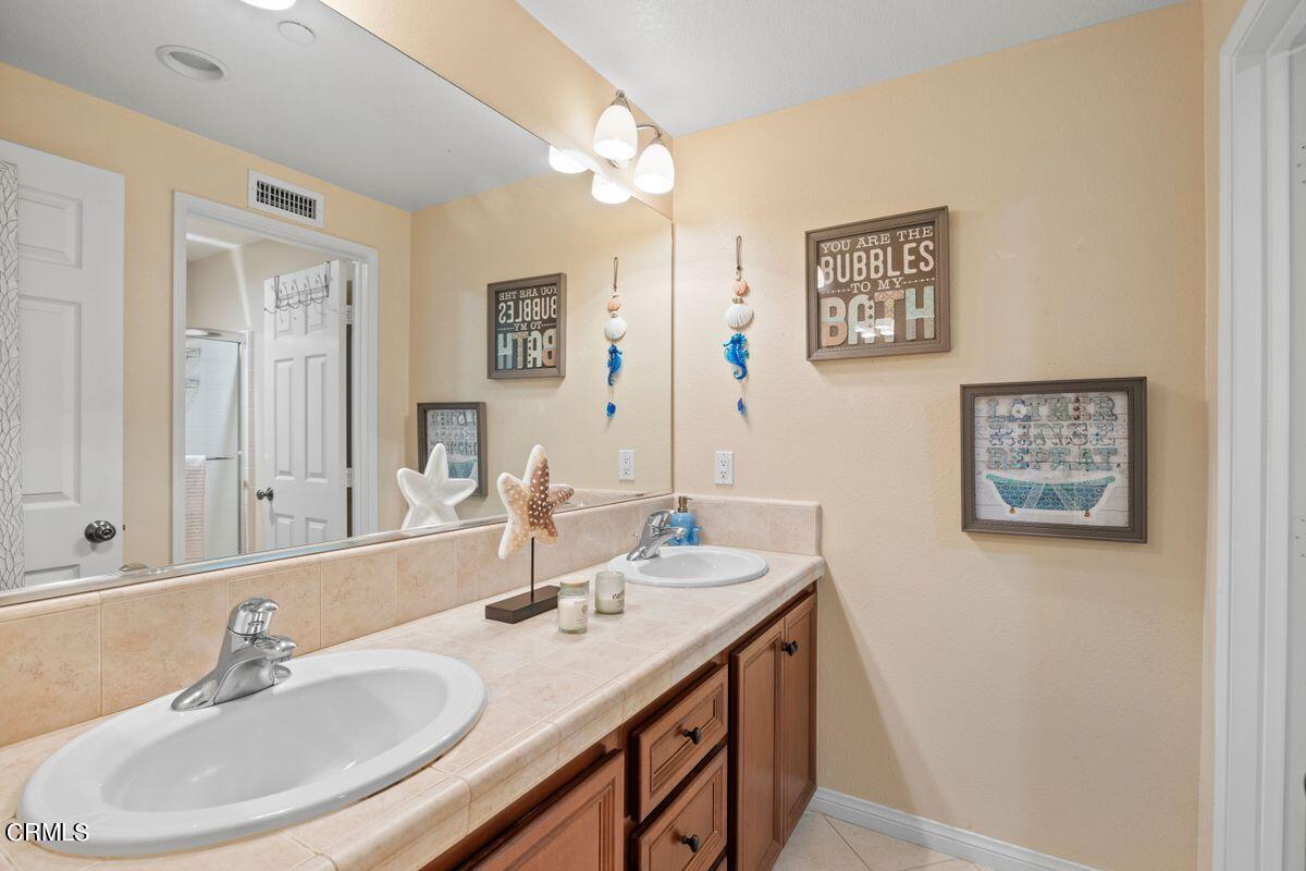 3004 Moonlight Park Avenue Oxnard, CA 93036 - Photo 10 of 28 a bathroom with a double vanity sink and a mirror