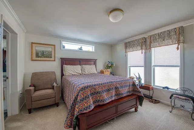 a bedroom with a bed and a couch next to a window