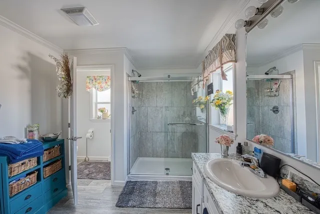 a bathroom with a tub shower sink and mirror