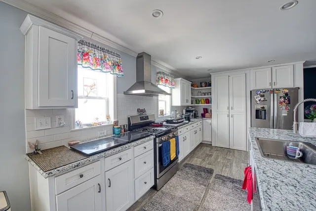 a kitchen with granite countertop a sink stove top oven and cabinets