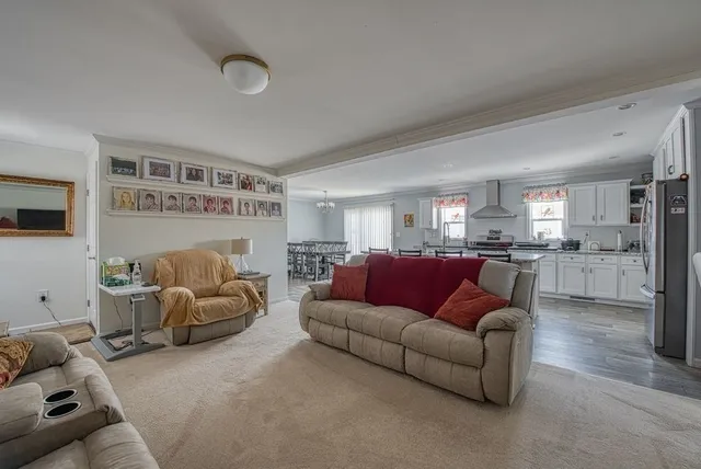 a living room with furniture and view of kitchen