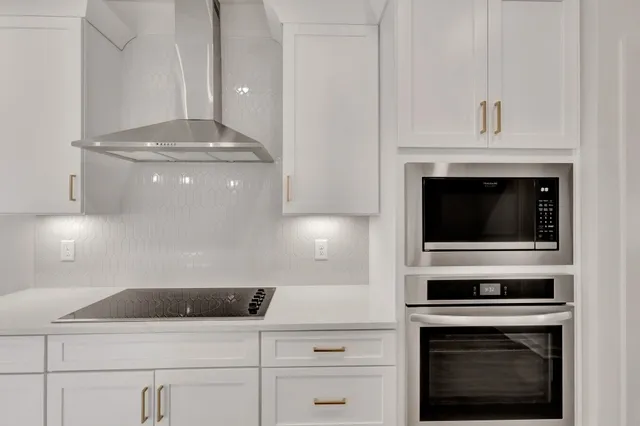a kitchen with a stove and white cabinets