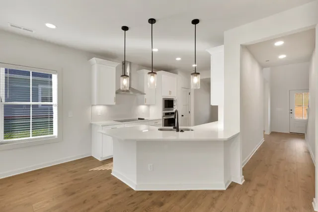 a kitchen with kitchen island white cabinets and stainless steel appliances