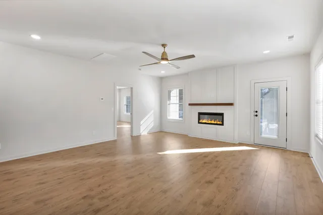 an empty room with windows and a ceiling fan