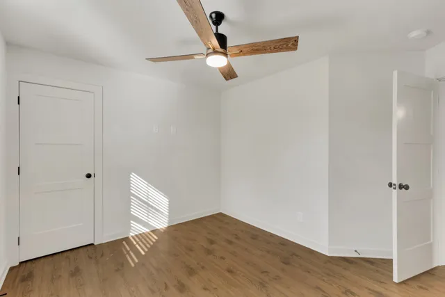 a view of empty room with wooden floor