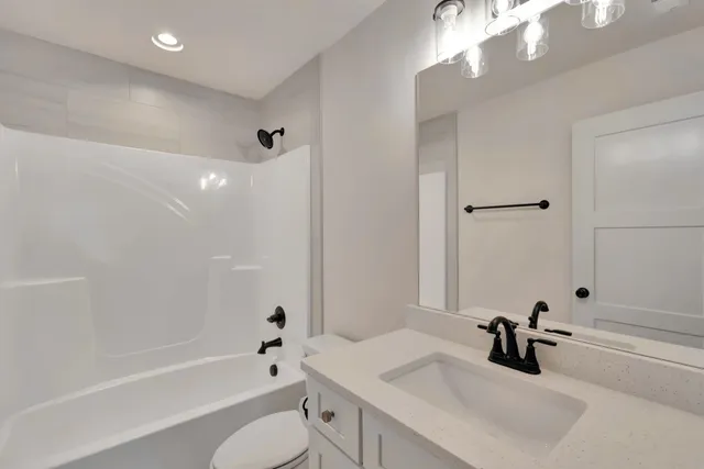 a bathroom with a tub a sink and a large mirror