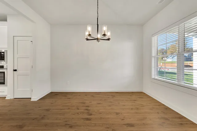 a view of a room with window a ceiling fan and wooden floor