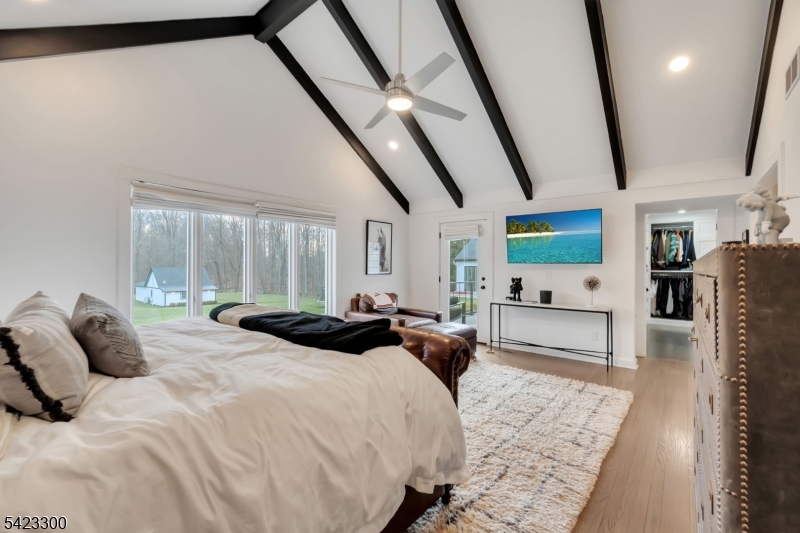 16 East Greenbrook Road North Caldwell, NJ 07006 - Photo 19 of 45 a large bedroom with a bed a flat screen tv and a couch