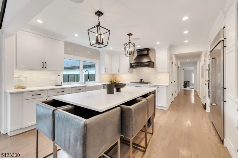 16 East Greenbrook Road North Caldwell, NJ 07006 - Photo 7 of 45 a kitchen with stainless steel appliances granite countertop a sink a stove a refrigerator and island with wooden floor