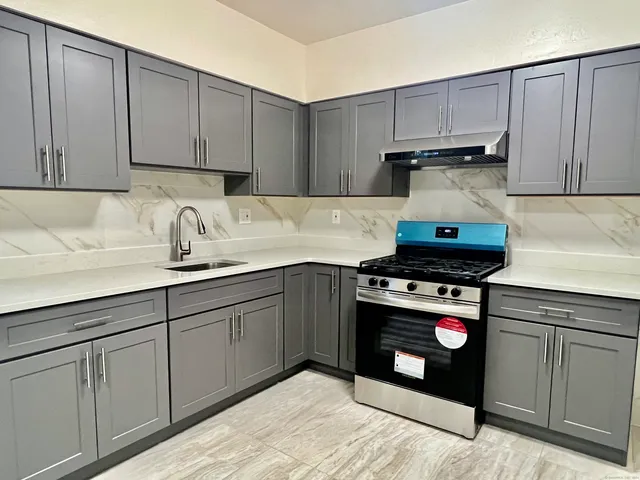 a kitchen with stainless steel appliances granite countertop a sink stove and cabinets