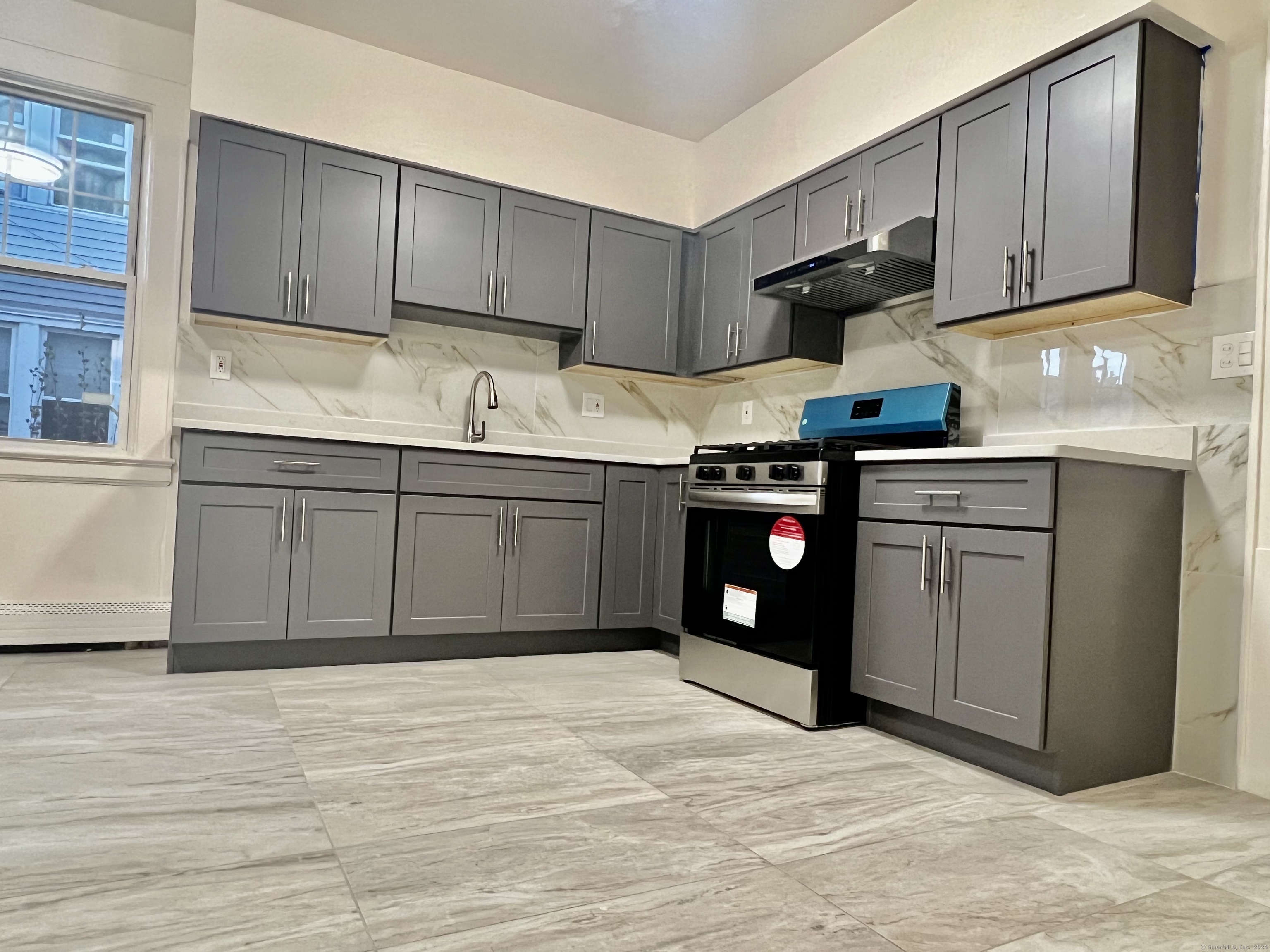 38 Wilson Street Stamford, CT 06902 - Photo 11 of 30 a kitchen with stainless steel appliances granite countertop a sink and cabinets with wooden floors