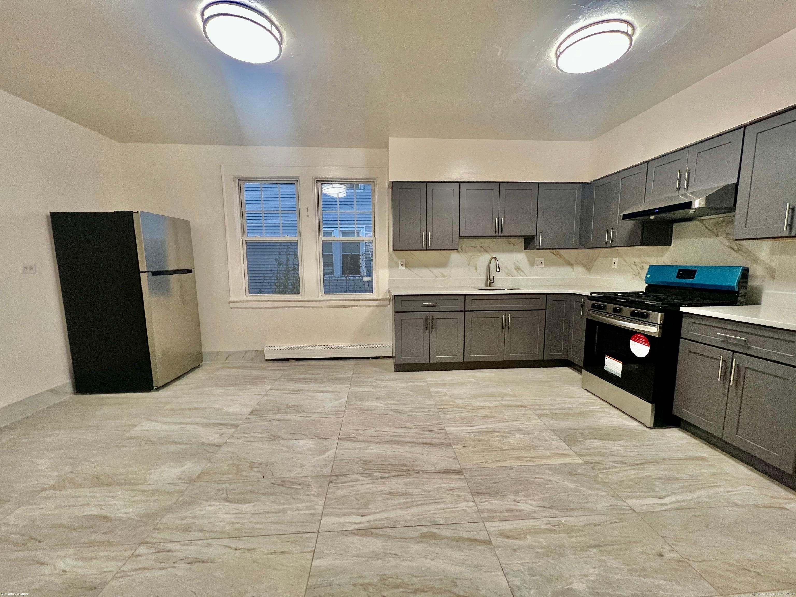 38 Wilson Street Stamford, CT 06902 - Photo 4 of 30 a kitchen with stainless steel appliances granite countertop a sink and cabinets