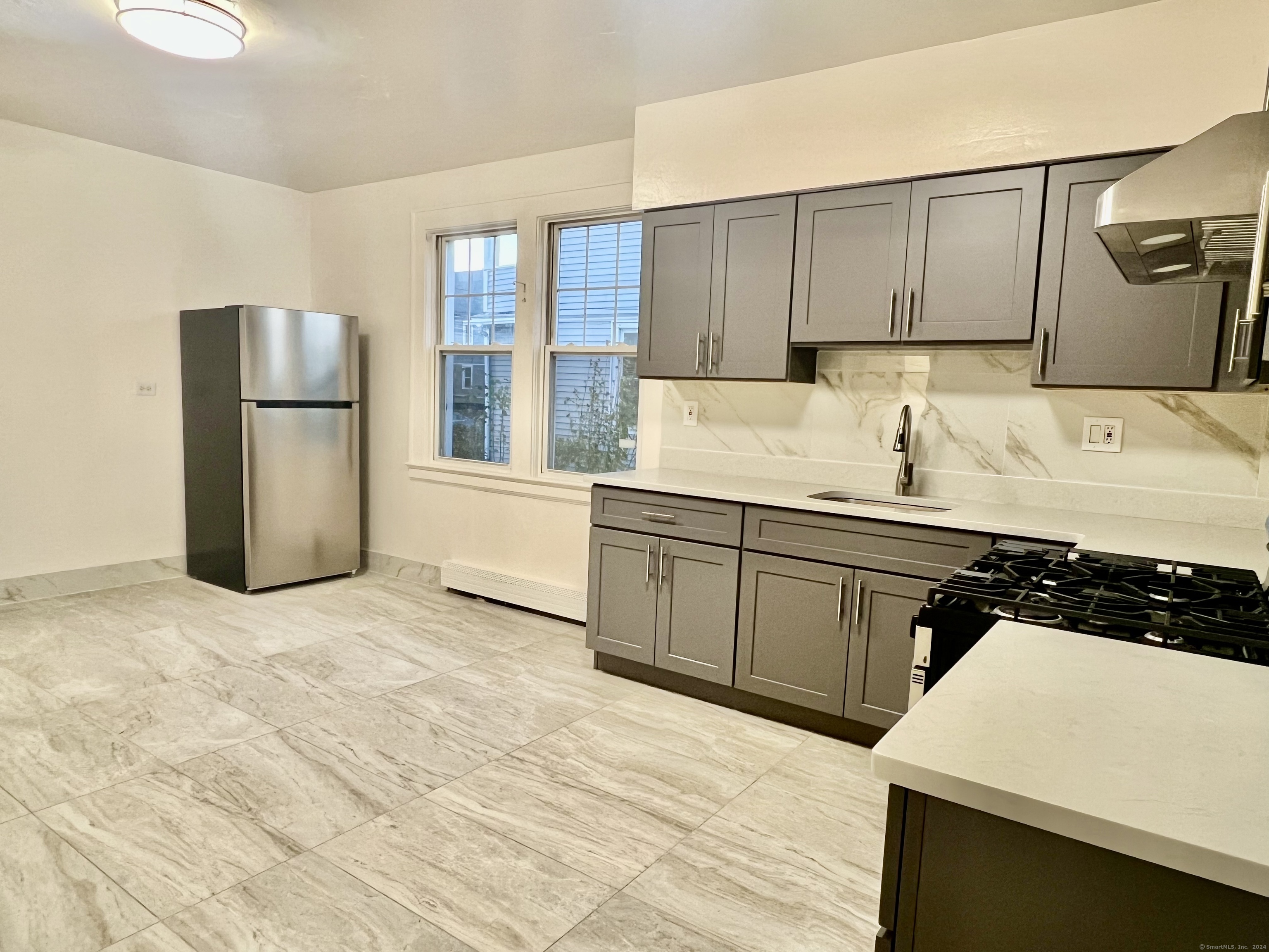 38 Wilson Street Stamford, CT 06902 - Photo 5 of 30 a kitchen with a sink a refrigerator and cabinets