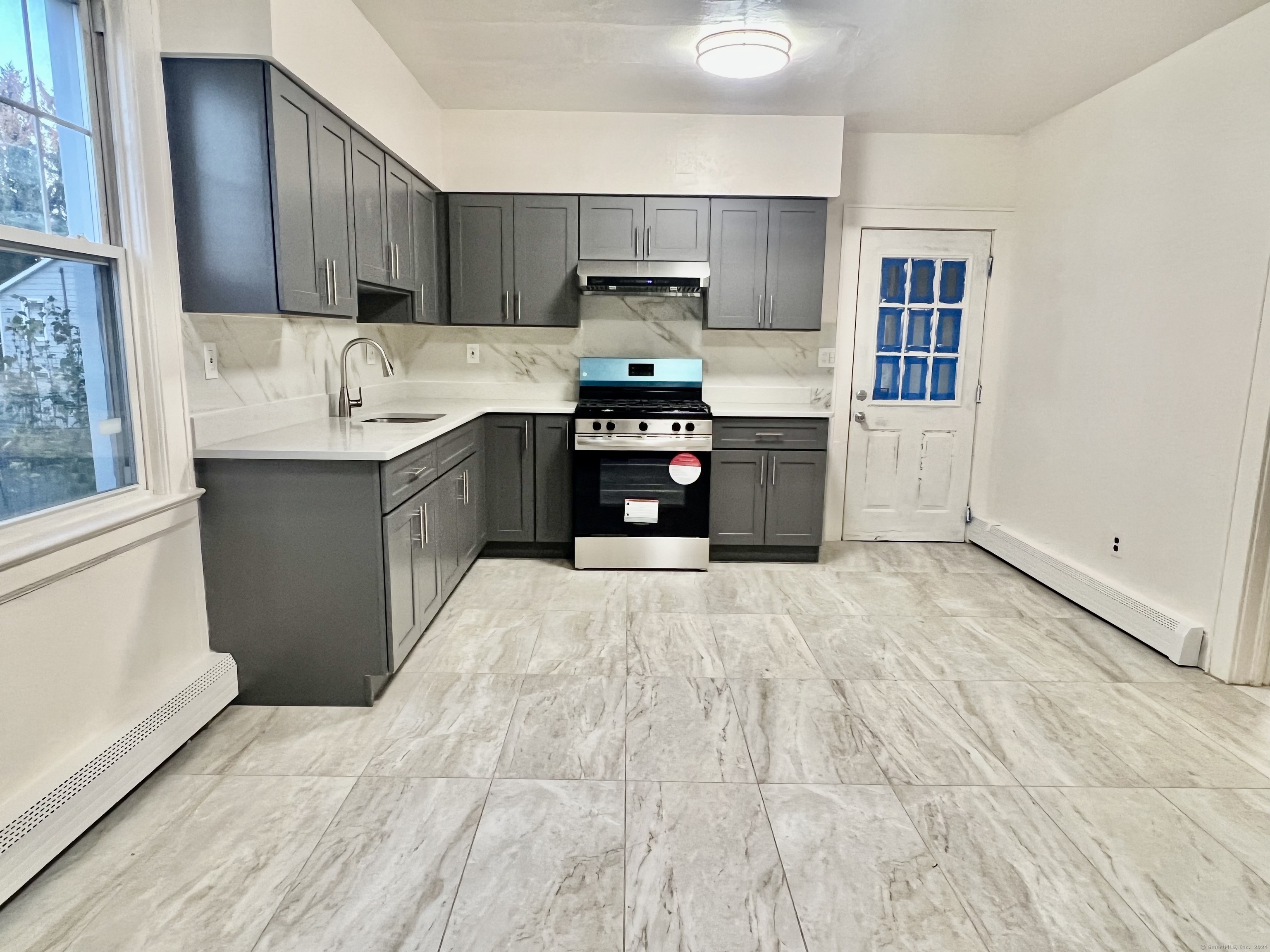 38 Wilson Street Stamford, CT 06902 - Photo 8 of 30 a kitchen with granite countertop a refrigerator stove and sink
