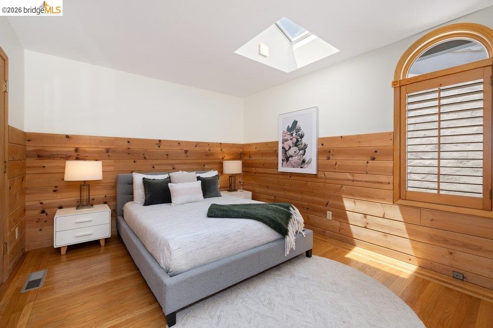 287 Purdue Avenue Kensington, CA 94708 - Photo 40 of 60 Room featuring wood-finish flooring, a skylight, and wood plank wall paneling