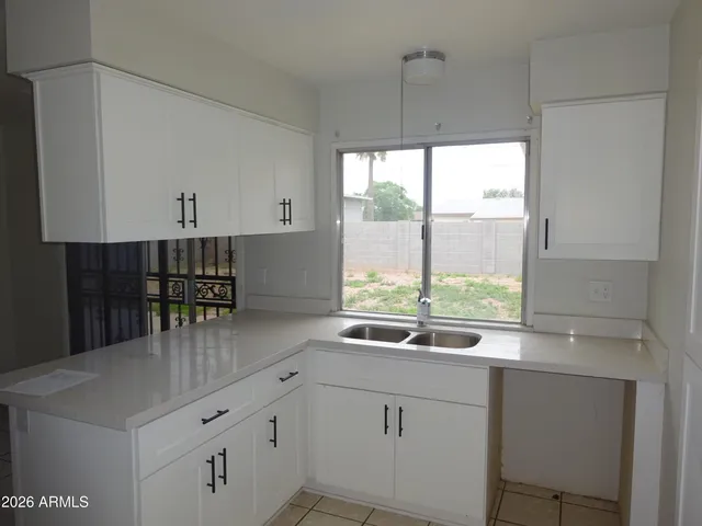 a kitchen with a sink and white cabinets