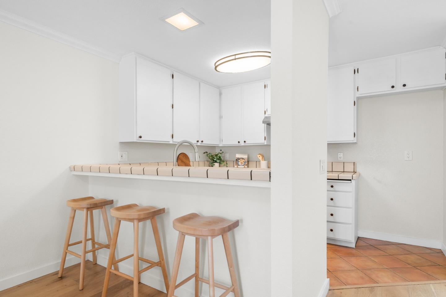 6101 Sheraton Place Aptos, CA 95003 - Photo 18 of 47 a white kitchen with a dining table chairs and white cabinets
