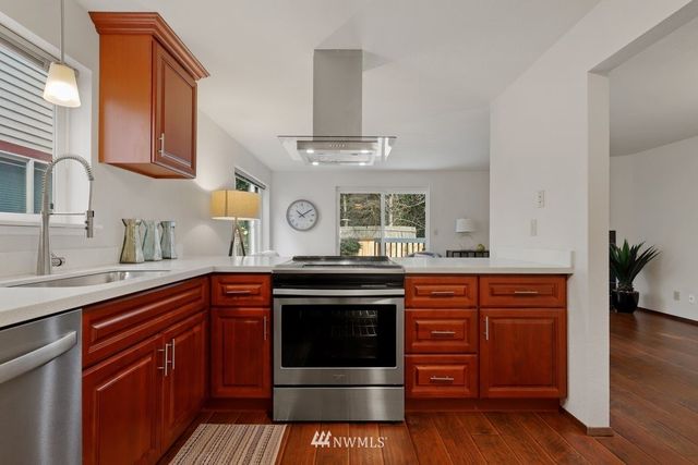 a kitchen with stainless steel appliances granite countertop a stove and white cabinets