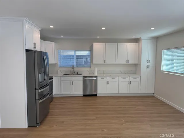 a kitchen with white cabinets and stainless steel appliances