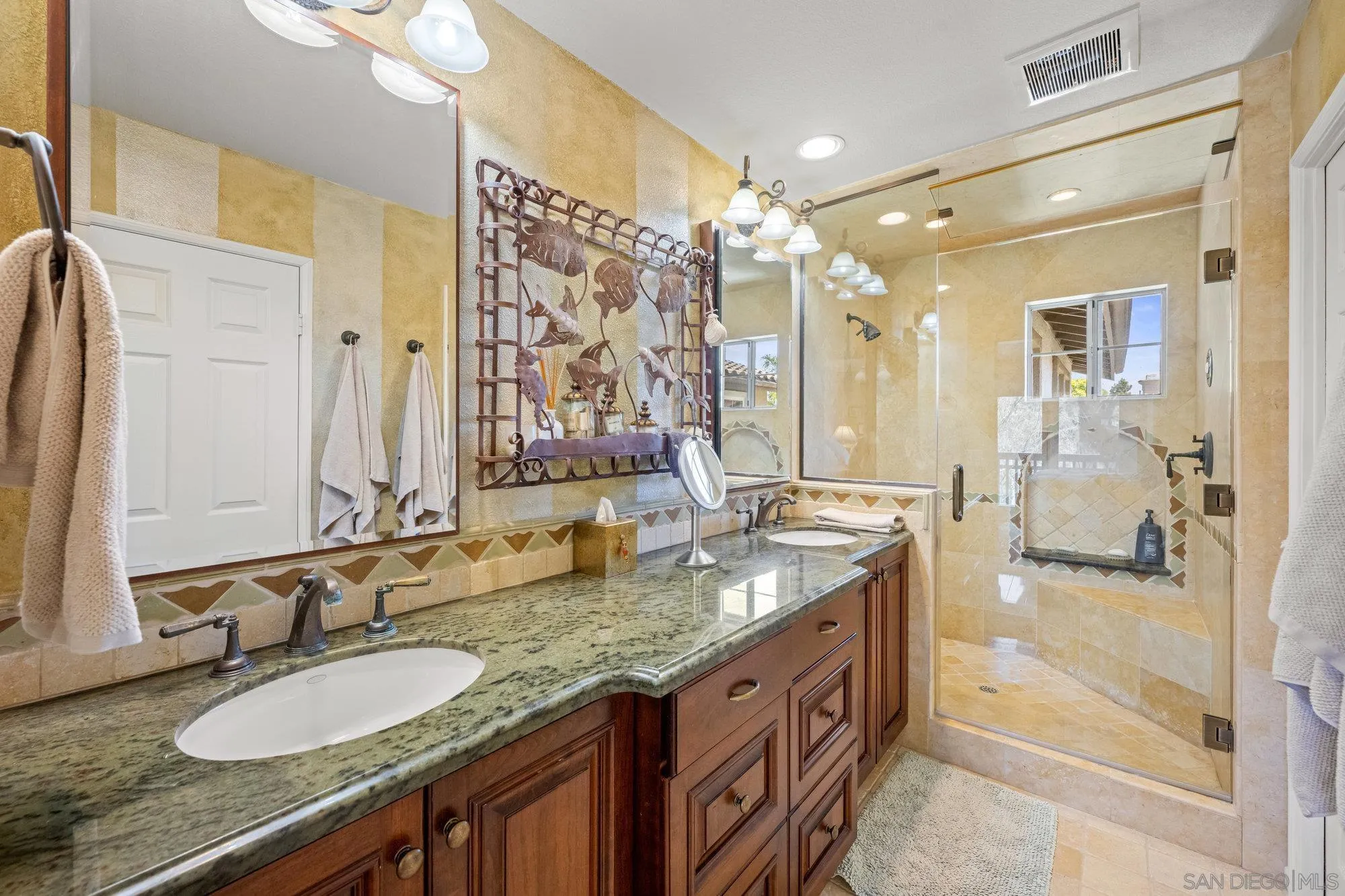 6845 Adolphia Drive Carlsbad, CA 92011 - Photo 13 of 33 a bathroom with a granite countertop double vanity sink and mirror with shower