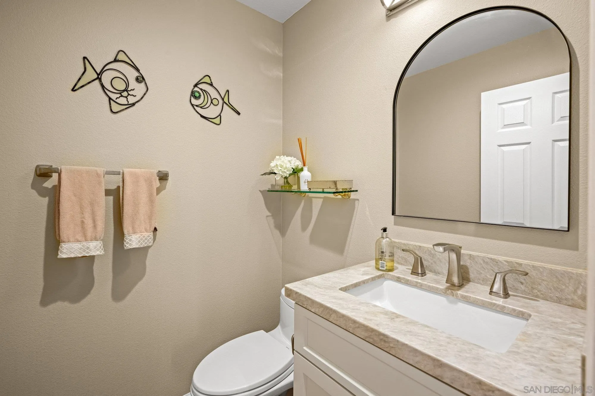 6845 Adolphia Drive Carlsbad, CA 92011 - Photo 18 of 33 a bathroom with a granite countertop sink a toilet and a mirror
