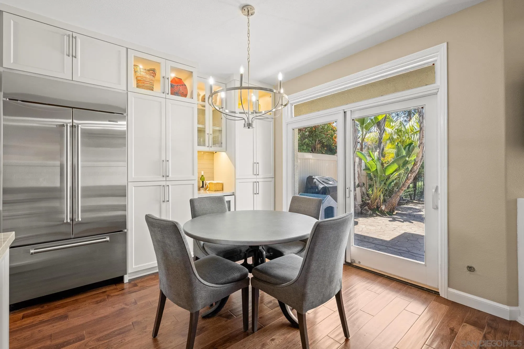 6845 Adolphia Drive Carlsbad, CA 92011 - Photo 9 of 33 a dining room with wooden floor a chandelier a wooden table and chairs