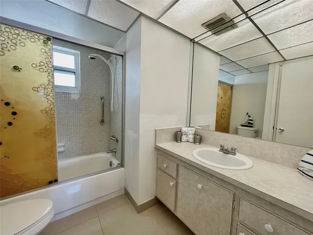 a view of an empty room with closet and mirror