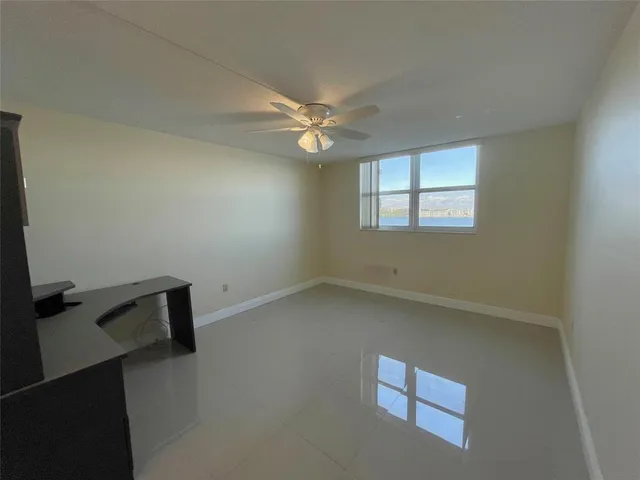 an empty room with windows and fan