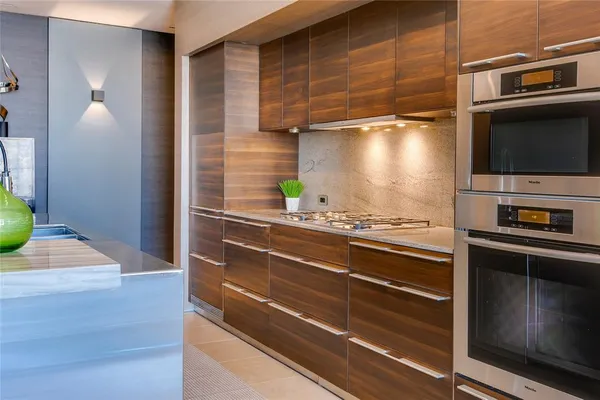 a kitchen with stainless steel appliances kitchen island granite countertop a stove and a refrigerator