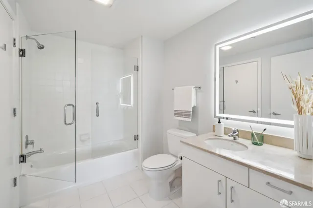 a bathroom with a granite countertop sink a toilet and shower